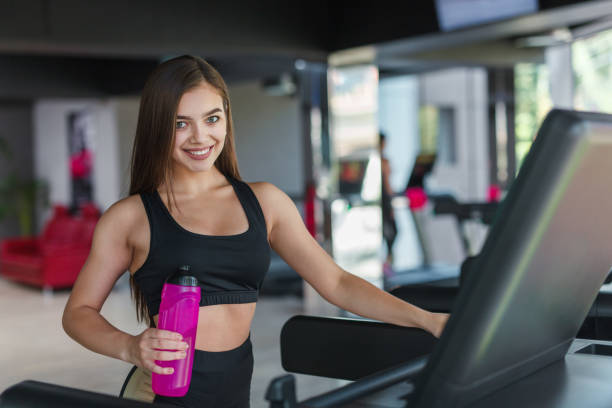 istock Charming sportswoman smiling at camera in gym 903548966