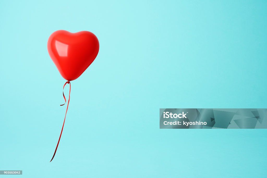 Globo de la forma de corazón rojo sobre fondo azul - Foto de stock de Símbolo en forma de corazón libre de derechos
