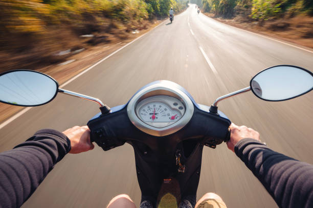 istock Rider driving scooter on an asphalt road. Motion blurred backgro 903553312