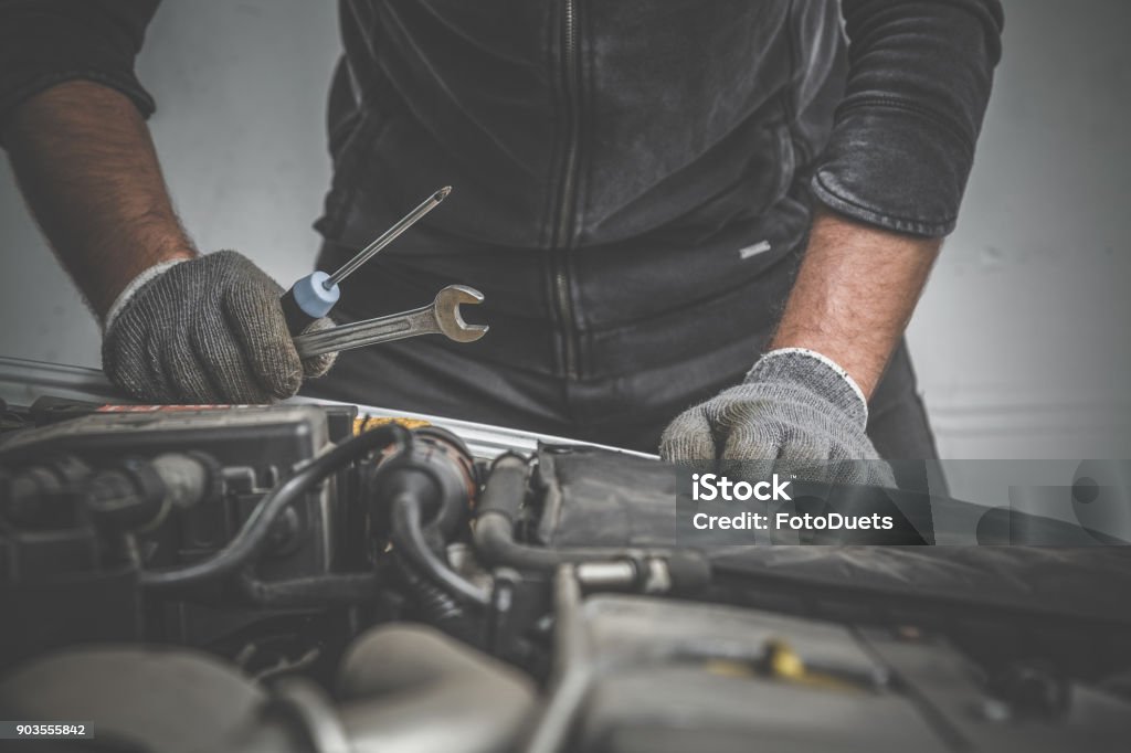 Car mechanic looking to the engine in the garage. Car motor repair. Problems and solutions concept. Auto Repair Shop Stock Photo