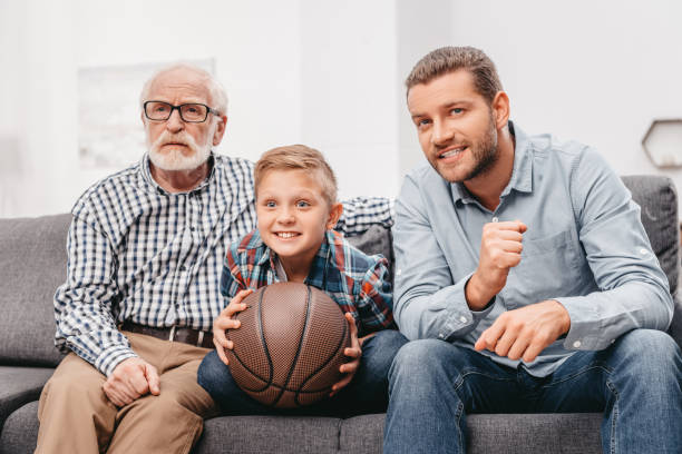 istock Family watching basketball at home 903559872