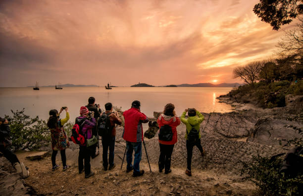 Photographers take Taihu sunset at the Turtle Head Islet Park. Wuxi, Jiangsu, China - March 24, 2016: Photographers take Taihu sunset at the Turtle Head Islet Park. wuxi photos stock pictures, royalty-free photos & images