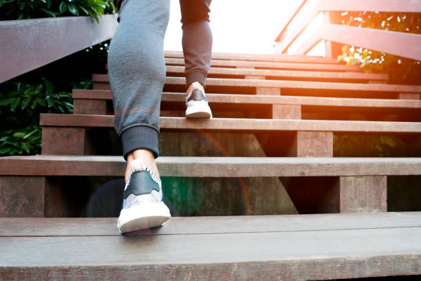 une étape d’homme jusqu'à la réussite, l’homme sport est escalade sur marche en bois - stepping photos et images de collection