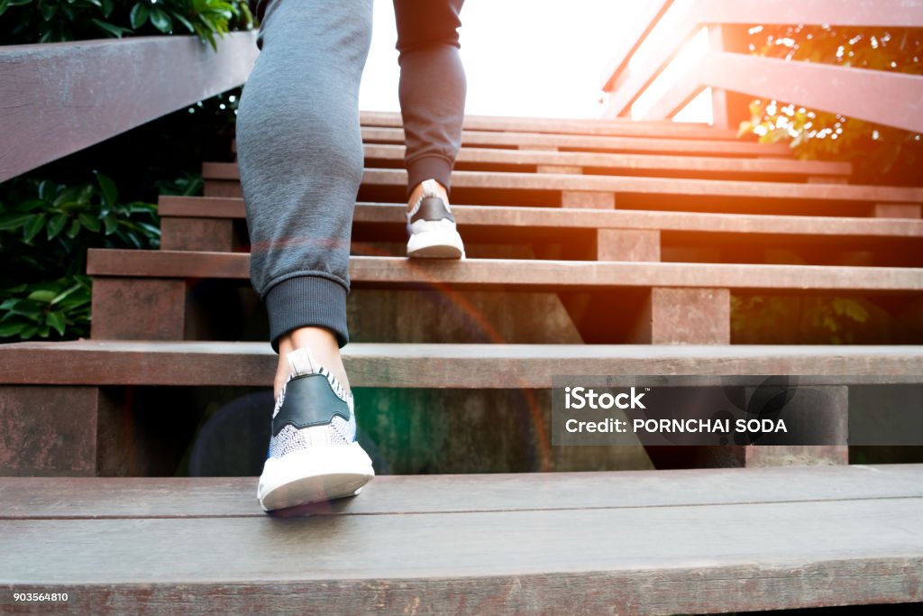 A man step up to success, sport man is climbing on wooden step Stepping Stock Photo