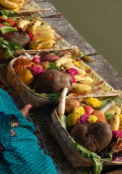 Photo of Hindu devotee offer prasad ,fruits,vegetables and other items and light lamp or diya, to pray sun God,at a lake,in Chhath Puja festival