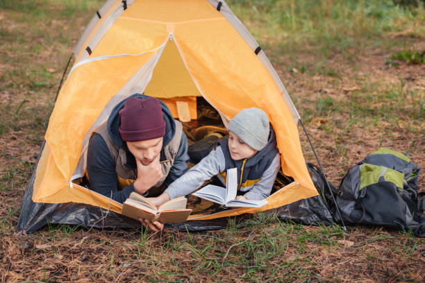 istock father and son reading books in tent 903575828