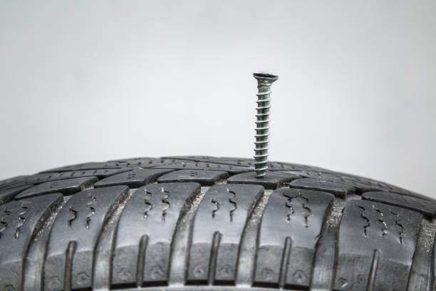 Screw in the black tire. Damaged tire problems and solutions concept.