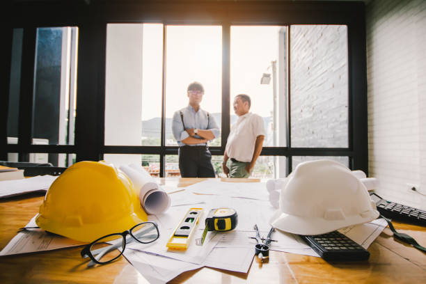 istock Close up,calculator,white hat engineers.Two Architects meeting work in the office background.Selective Focus 903578370