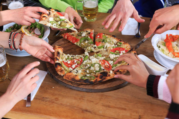 istock Friends eating pizza in restaurant 903580614