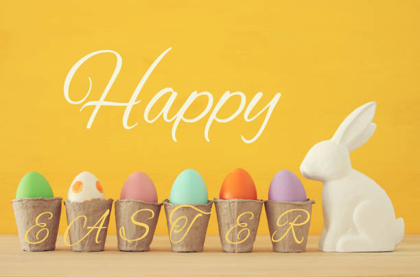 istock Cute bunny next to easter colorful eggs over colorful background. 903583628
