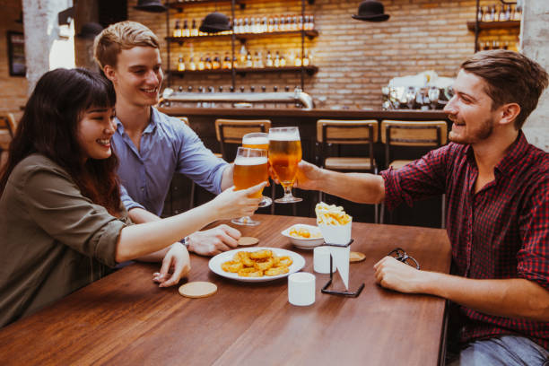 istock Three Friends Clinking Glasses of Beer in Pub 903583932
