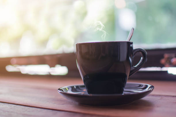 istock A black cup of hot coffee with steaming on the wooden table 903584272