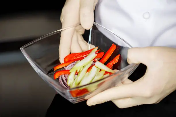 Chef prepared fresh vegetables for salad.