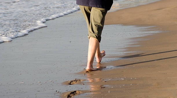 istock woman walking along beach 90358879
