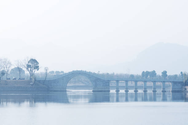 istock rock arch bridge over tranquil lake 903590042