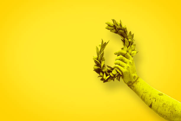 istock Hand holds a laurel wreath - bronze statue on solid color background - Success and fame concept image with copy space 903595658