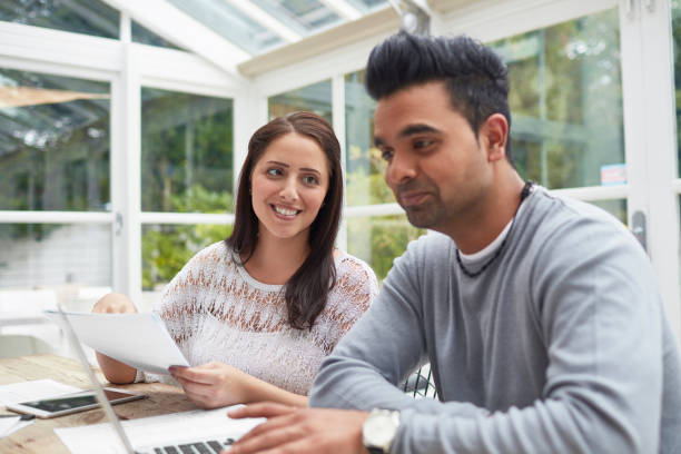 istock Woman looking at man paying bills at home 903597202