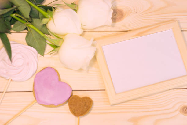 istock White roses on natural wooden background 903597760