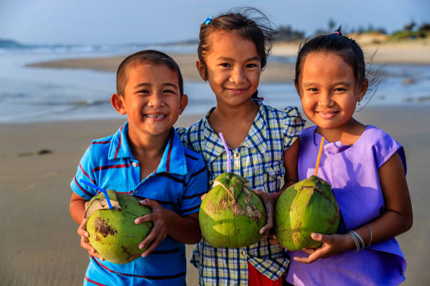 istock Vietnamese children holding coconuts on the beach, Vietnam 903598320