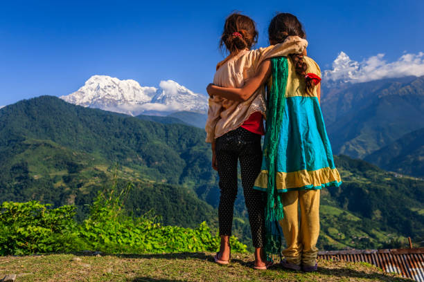 Nepali little girls looking at Annapurna South Nepali little girls, Annapurna Range on background. The Annapurna region is in western Nepal where some of the most popular treks (Annapurna Sanctuary Trek, Annapurna Circuit) are located. Peaks in the Annapurnas include 8,091m Annapurna I, Nilgiri and Machhapuchchhre. The Annapurna peaks are among the world's most dangerous mountains to climb. annapurna circuit photos stock pictures, royalty-free photos & images