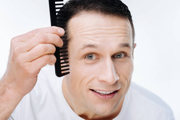 istock Portrait of a nice positive man using a comb 903604390