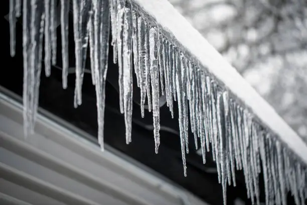 Icicles hanging off of a house in the winter