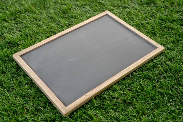 istock Abstract chalk blackboard with wood border frame on grass floor included copyspace ready used as background for add text or graphic 903604870