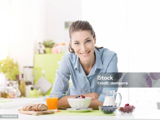 Photo libre de droit de Femme Souriante Prenant Son Petit Déjeuner À La Maison banque d'images et plus d'images libres de droit de Nutritionniste