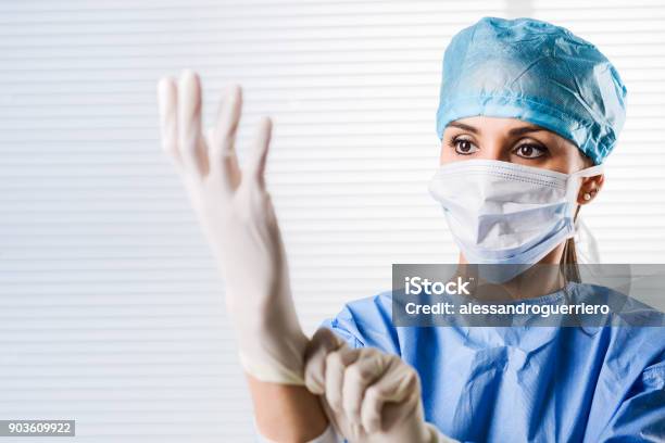 Photo libre de droit de Femme Médecin Chirurgien Mettre Des Gants Chirurgicaux banque d'images et plus d'images libres de droit de Paire de gants