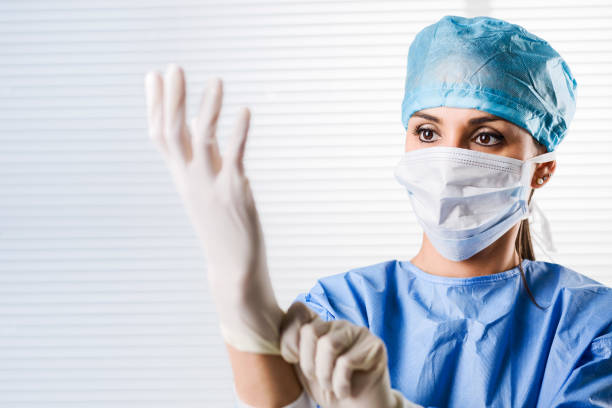 Female doctor Surgeon putting on surgical gloves stock photo