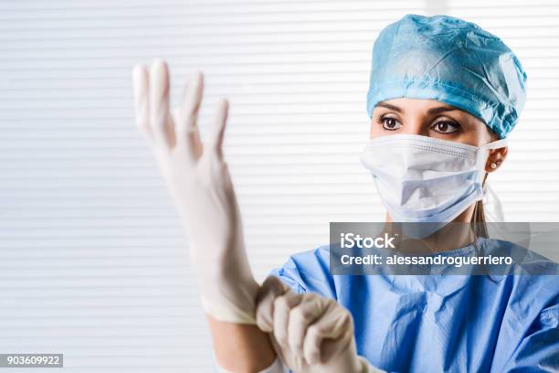 Female Doctor Surgeon Putting On Surgical Gloves Stock Photo - Download Image Now - Glove, Doctor, Nurse