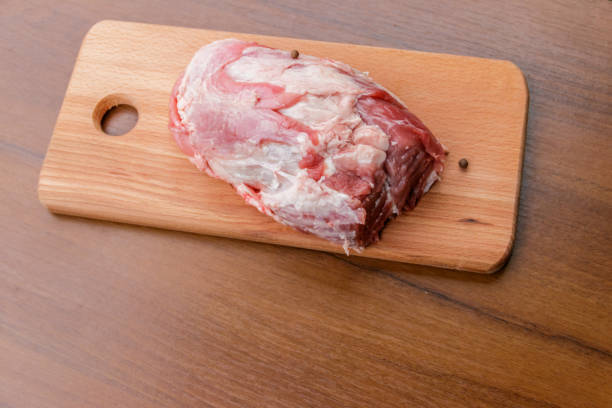 istock Raw pork meat on cutting board on a table 903612998