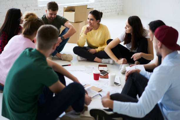 istock Young positive people spending time together sitting in loft interior office talking to each other in friendly atmosphere, coworkers having brainstorming session in new office sharing creative ideas 903617592