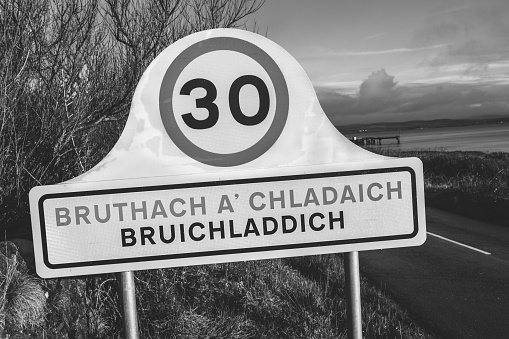 Entrance road sign to the village of Bruachladdich, with its gaelic equivalent translation, just north of Port Charlotte on the island of Islay, Scotland.