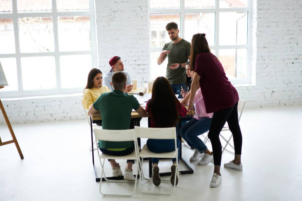 istock Working crew listening attentively to coach explanation while discussing successful strategies for business startup, professional leader of architects group making workshop in modern coworking space 903624034