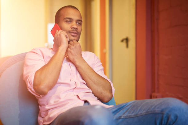 istock Pensive successful creative afro american journalist having mobile conversation with colleague and planning working process for online business via modern mobile phone sitting in coworking office 903626080