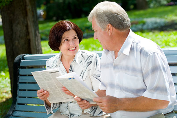 istock Happy elderly couple reading together outdoors 90363044