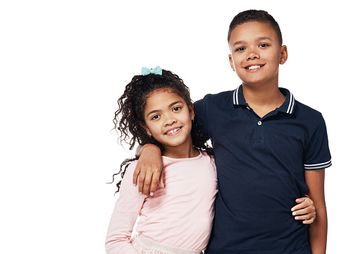 Studio portrait of a happy boy and girl embracing one another against a white background