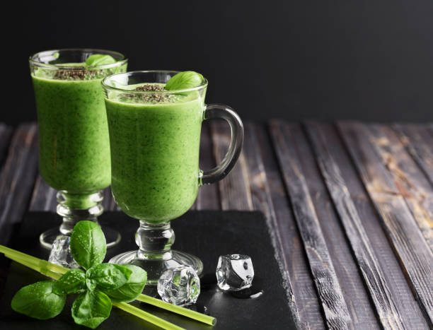 istock Blended green smoothie with ingredients on wooden table 903633360