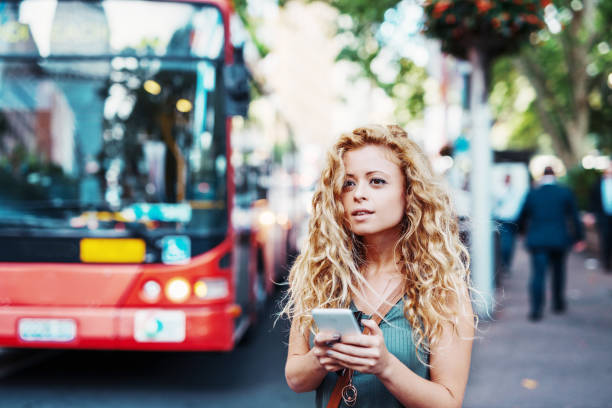 mulher usando o app móvel na paragem de autocarro - bus public transportation sydney australia australia - fotografias e filmes do acervo