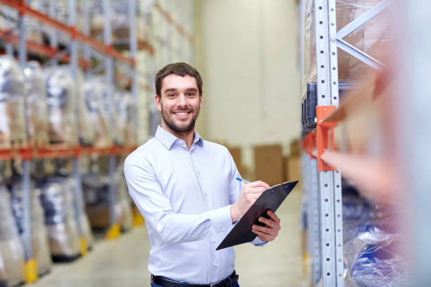 istock happy businessman with clipboard at warehouse 903636386