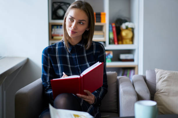 istock Dreamy young teen hipster girl making notes in diary writing essay for homework task spending time in university campus,creative female journalist satisfied with brilliant idea for article publication 903636388