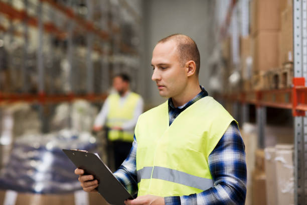 istock man with clipboard in safety vest at warehouse 903636610