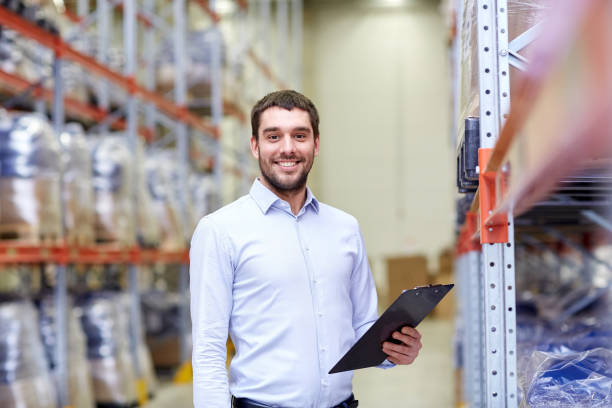istock happy businessman with clipboard at warehouse 903637806