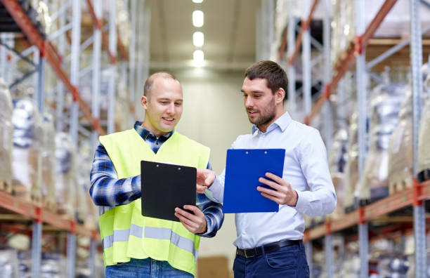 istock worker and businessmen with clipboard at warehouse 903638798