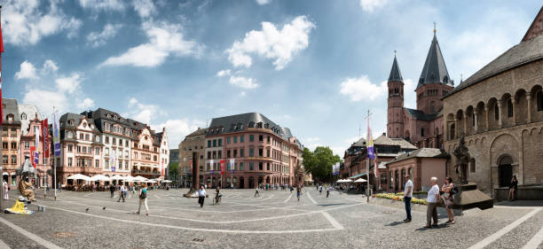 Marketplace in Mainz and St Martin`s Cathedral, Germany, Europe Panoramic view of Marktplatz in Mainz, Germany. The square is surrounded by Baroque buildings and the Cathedral. It was built around 975 .People are walking, watching and sitting in Cafes . mainz stock pictures, royalty-free photos & images