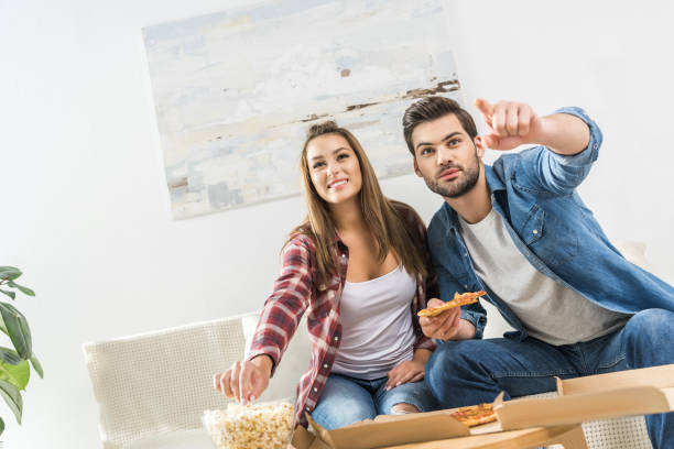 istock couple watching tv with snacks 903644996