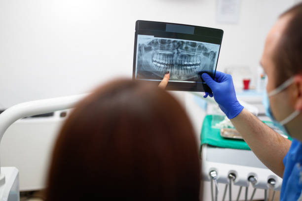 istock Dentist showing a patient her x-ray 903646010