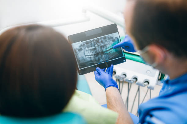 istock Dentist showing a patient her x-ray 903648474