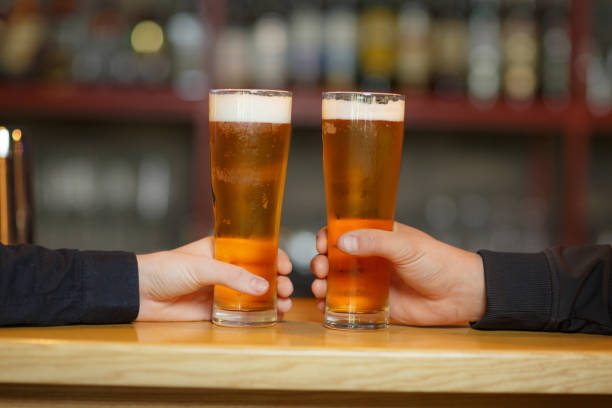 istock Two men cling to full glasses with a beer. Close-up. 903649184